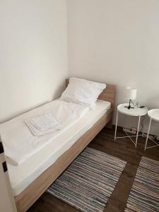 a bedroom with a bed and a table with a lamp at SkyApartment#101 in Frankfurt/Main