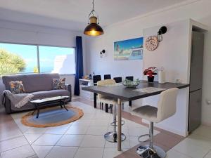 Sunny Tenerife Apartment - ocean views في تاكورونتي: مطبخ وغرفة معيشة مع طاولة وأريكة