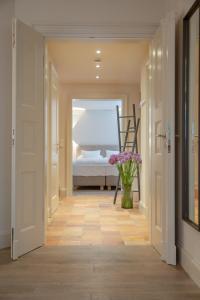 a hallway with a bed and a vase of flowers at NEU Dorfhues Anja friesisch modern urlauben in Kampen Sylt in Kampen