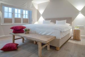 a bedroom with a large bed and a wooden table at NEU Dorfhues Anja friesisch modern urlauben in Kampen Sylt in Kampen