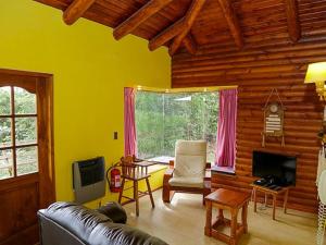 Cabañas Altos del Lago في بوكون: غرفة معيشة مع أريكة جلدية وتلفزيون