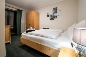 Bergblick Appartements في باد جاستاين: غرفة نوم بسرير ذو شراشف بيضاء