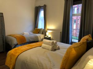 een slaapkamer met 2 bedden en een teddybeer erop bij Comfort Home From Home Bolton Central Hilden St - Sleeps - 10 in Bolton