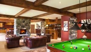 a living room with a pool table and a fireplace at Stonefly Lodge in Stanley Brook