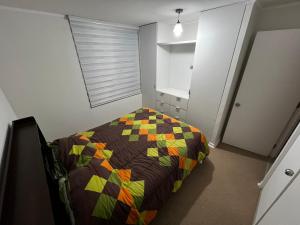 1 dormitorio con 1 cama con colcha colorida en Departamento hasta 6 personas en Quintero, en Quintero