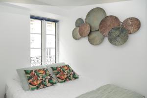 una stanza con due specchi a muro e un letto di Nets Inn Apartment - Gare de Lyon a Parigi