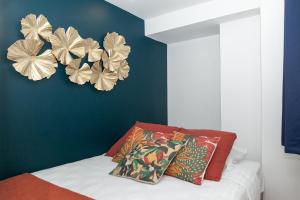 a bedroom with a blue wall with flowers on the wall at Nets Inn Apartment - Gare de Lyon in Paris
