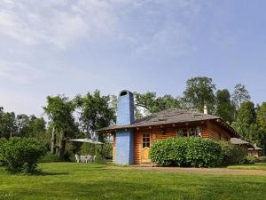 a log cabin with a chimney in a field at Cabañas Altos del Lago in Pucón