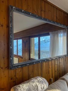 een spiegel aan de muur van een slaapkamer bij Jolie appart cozy, Ski in Ski out in Veysonnaz
