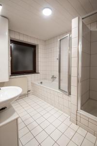 Bergblick Appartements في باد جاستاين: حمام مع حوض ومغسلة وتلفزيون