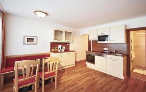 a kitchen with white cabinets and a table and chairs at Amazing Apartment In Flachau With 2 Bedrooms And Wifi in Flachau
