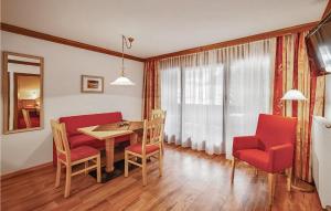 a dining room with a table and red chairs at Awesome Apartment In Flachau With Kitchen in Flachau