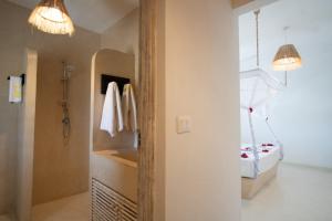 baño con cama, lavabo y 2 luces en Weber Zazu - Maisha Resort, en Watamu
