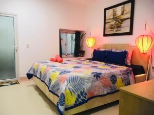 una camera da letto con un letto con un piumone colorato di Casa Vi Mia a Ấp Thiện Sơn