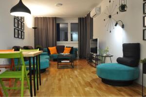 a living room with a couch and a table and chairs at Sarajevo Tower 24th floor apartment in Sarajevo