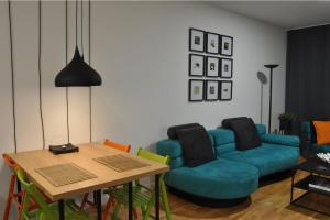 a living room with a blue couch and a table at Sarajevo Tower 24th floor apartment in Sarajevo