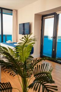 um quarto de hotel com uma palmeira num quarto em Panorama Orbi Resort em Batumi