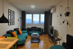 uma sala de estar com sofás azuis e uma televisão em Sarajevo Tower 24th floor apartment em Sarajevo