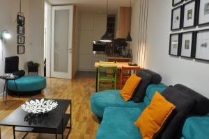 a living room with a blue couch and a table at Sarajevo Tower 24th floor apartment in Sarajevo