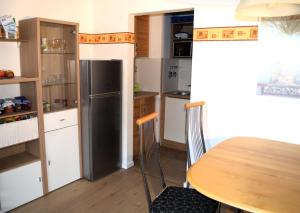 eine Küche mit einem Tisch und einem Kühlschrank in der Unterkunft Wanderglück in Missen-Wilhams