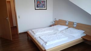 ein Bett mit weißer Bettwäsche in einem Schlafzimmer in der Unterkunft Haus Südstrand in Göhren
