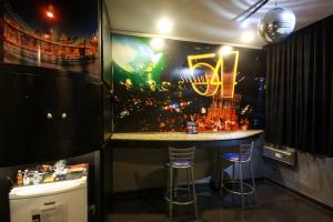 a bar in a room with a painting on the wall at Lina Motel Tatuapé in Sao Paulo