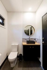 a bathroom with a toilet and a sink and a mirror at Flame Tree Retreat in Margaret River Town