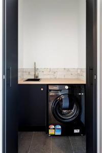 una cocina con lavadora bajo un fregadero en Flame Tree Retreat, en Margaret River Town