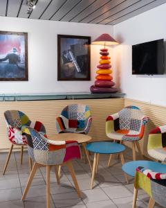 une salle d'attente avec des chaises colorées et une table dans l'établissement Kyriad Prestige Les Sables d'Olonne - Plage - Centre des Congrès, à Les Sables-dʼOlonne