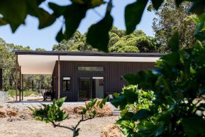 una pequeña casa con un exterior negro en Flame Tree Retreat, en Margaret River Town
