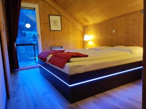 um quarto com uma cama num quarto de madeira em Wohlfuehl-Chalet-Alpengloeckchen em Stadl an der Mur