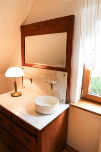 a bathroom with a mirror and a lamp on a dresser at Forsthaus Hubertus in Densberg