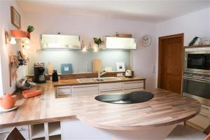 a kitchen with a wooden counter top with a sink at Forsthaus Hubertus in Densberg +16 photos