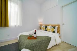 Un dormitorio con una cama y una mesa con una botella de vino en (J1) Ubicado en Madrid Centro - 5 personas. en Madrid