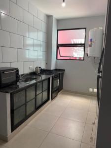 a kitchen with black and white appliances and a window at LITZ in Concepción