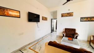 sala de estar con sofá y TV en la pared en Omkar Palace, en Udaipur