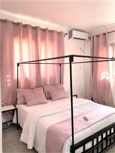 um quarto com 2 camas e cortinas cor-de-rosa em Natoose Lodge em Saint-Louis