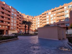 a large apartment building with palm trees in a courtyard at APARTAMENTO PLAZA DEL AYUNTAMIENTO con PARKING in Linares
