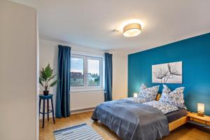 Dormitorio azul con cama y ventana en Apartement Hangarstein en Kassel
