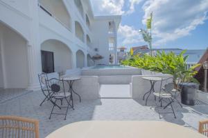 um pátio com mesas e cadeiras e uma piscina em RoomQuest The Peak Patong Hill em Praia de Patong