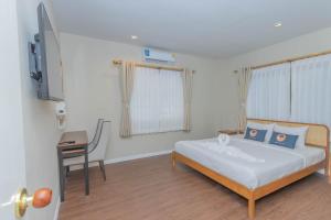 una camera con letto, scrivania e TV di RoomQuest The Peak Patong Hill a Patong Beach