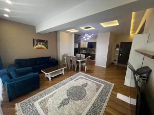 ein Wohnzimmer mit einem blauen Sofa und einem Tisch in der Unterkunft Park Azure 11523 in Baku