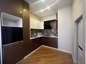a kitchen with brown cabinets and a wooden floor at Park Azure 11523 in Baku