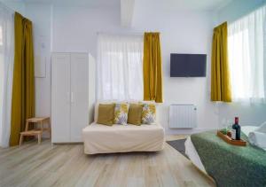 uma sala de estar com um sofá branco e cortinas amarelas em (J1) Ubicado en Madrid Centro - 5 personas. em Madrid