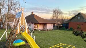 a playground with a slide in front of a house at ПростоРа in Khalepʼye