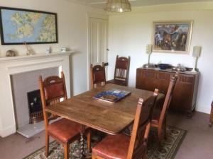 a dining room with a wooden table and chairs at Ardnadrochet Cottage in Lochdon