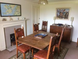 Un comedor con mesa y sillas de madera. en Ardnadrochet Cottage, en Lochdon