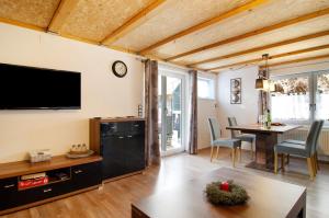 uma sala de estar com uma televisão de ecrã plano e uma mesa em Schönfeld em Stockach
