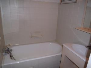 une salle de bain blanche avec une baignoire et un lavabo dans l'établissement Studio cosy 4 pers au cœur de Cauterets - FR-1-234-146, à Cauterets 7 autres photos