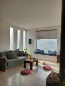 a living room with a couch and a window at Habitación en Casa de mar in Quequén